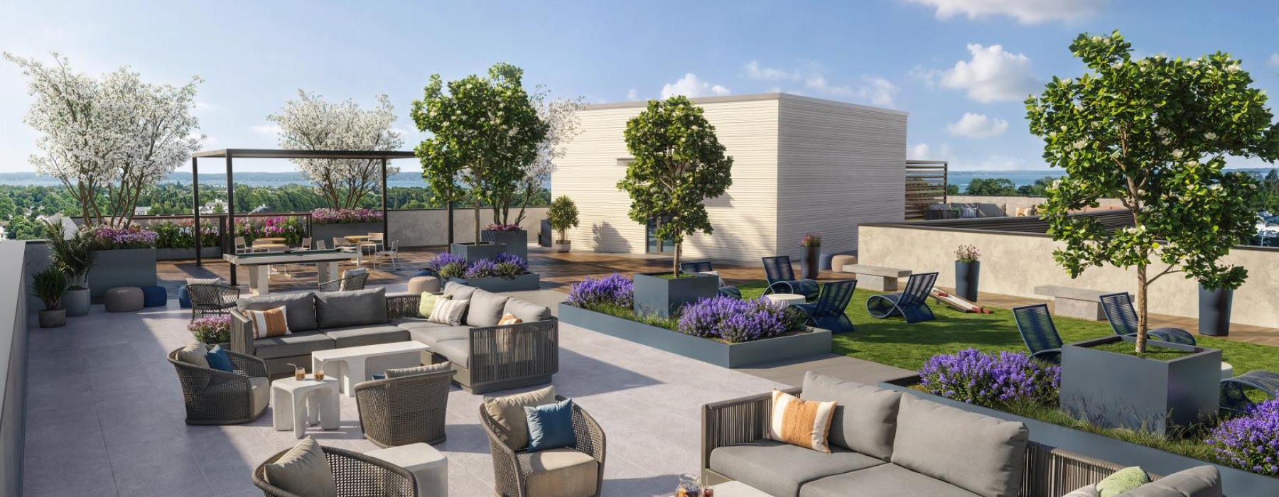 a spacious roof-top patio with lounge seating and lush landscaping
