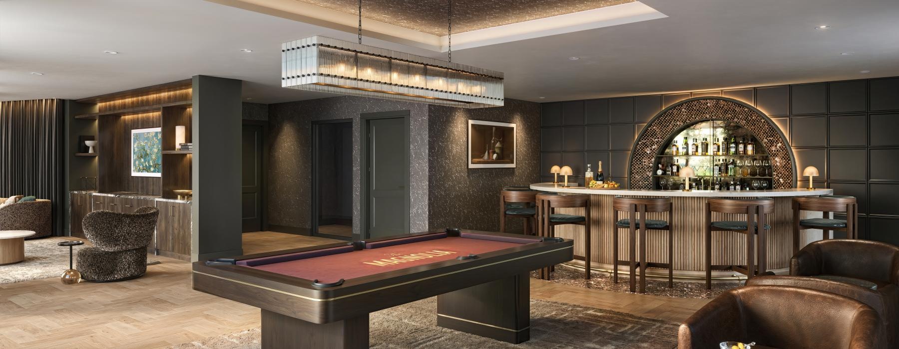 a billiards room with a pool table, bar and lounge seating